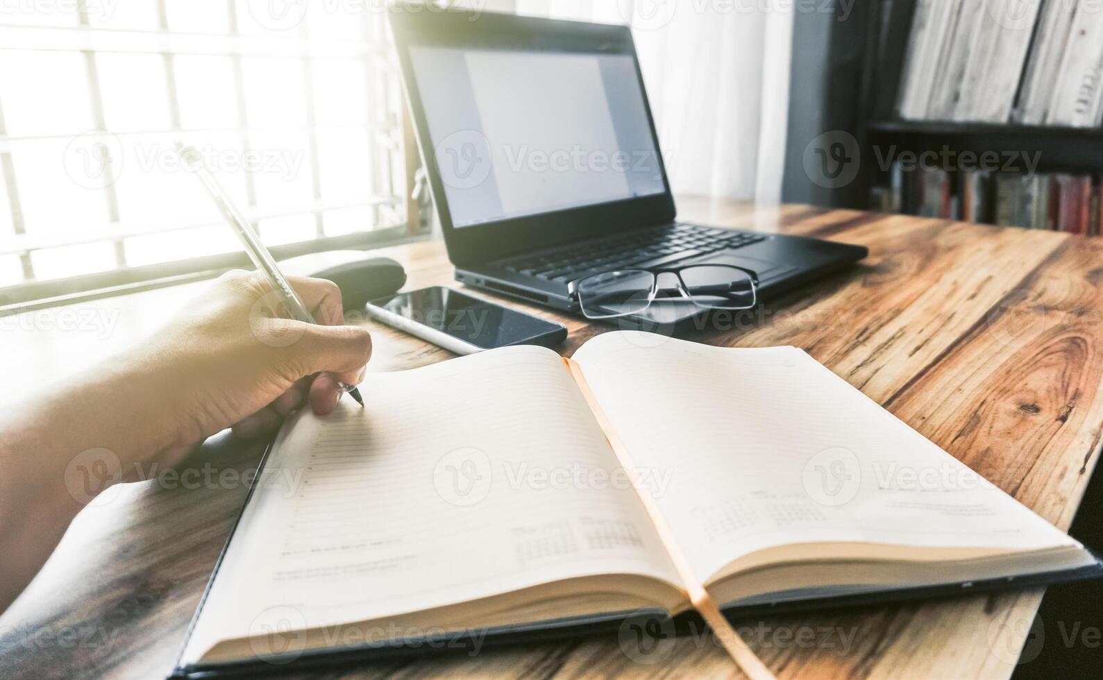 A closeup shot of a person writing in a journal at an office photo