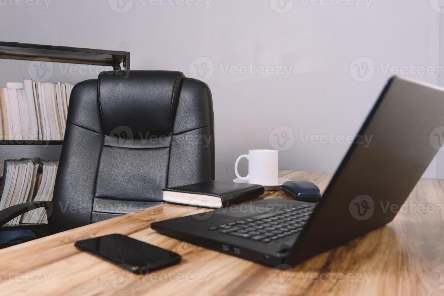 an office with a chair a desk a laptop a phone a notebook and a cup of coffee. concept background. photo