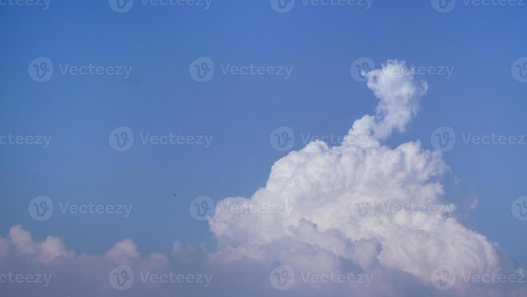 White fluffy clouds open for fantasy idea shape against bright blue sky for background with copy space, graphic resource, cloud motion from the wind photo