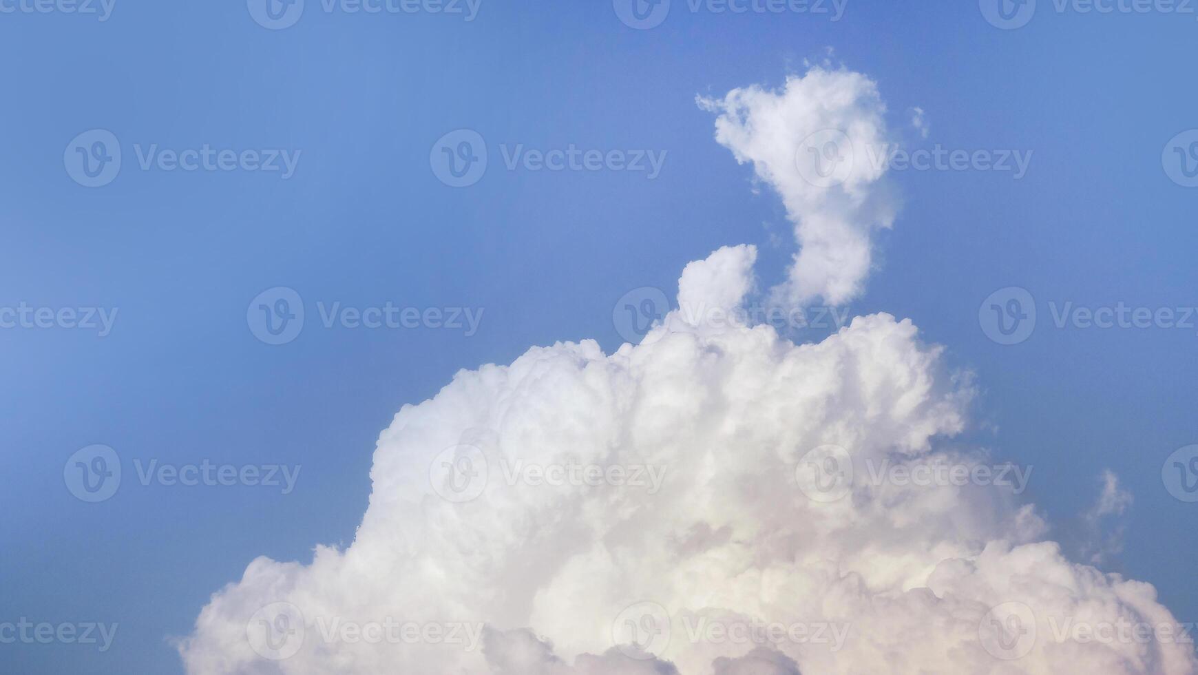 White fluffy clouds open for fantasy idea shape against bright blue sky for background with copy space, graphic resource, cloud motion from the wind photo