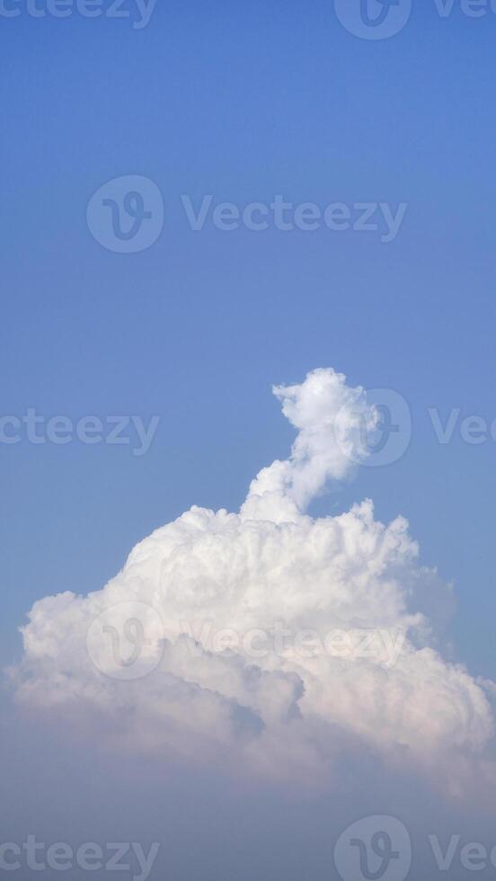 White fluffy clouds open for fantasy idea shape against bright blue sky for background with copy space, graphic resource, cloud motion from the wind photo