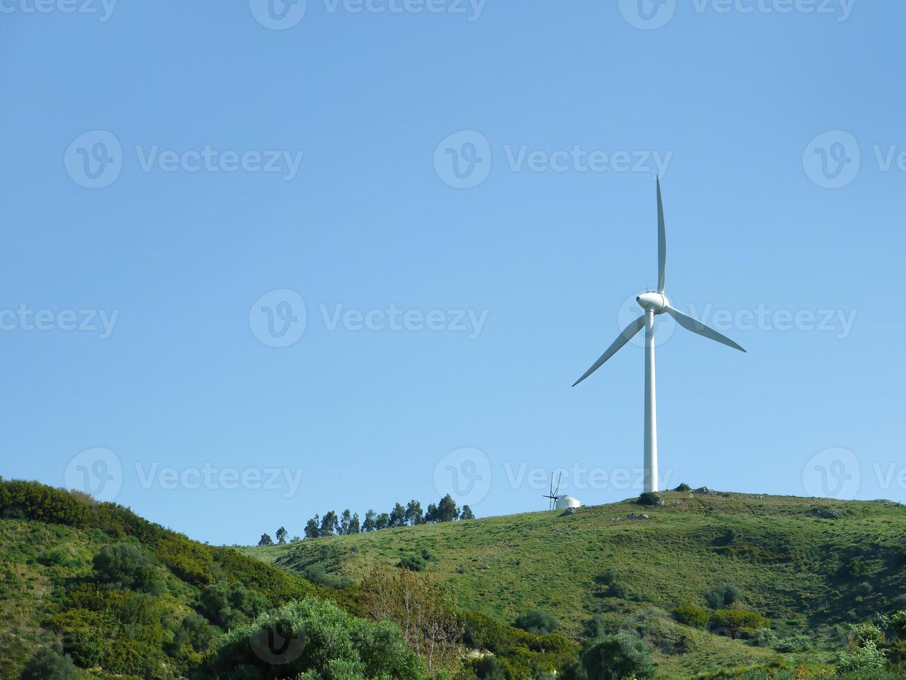 Sustainable eco power energy concept. Modern wind turbine on green hilltop, generating clean renewable and pollution-free energy farm, Windmill generator photo