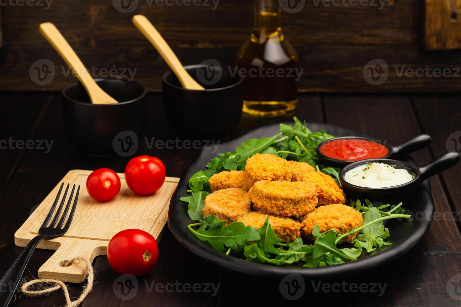 pollo pepitas en un Rúcula y salsa, especias, baturrillo en un de madera antecedentes foto