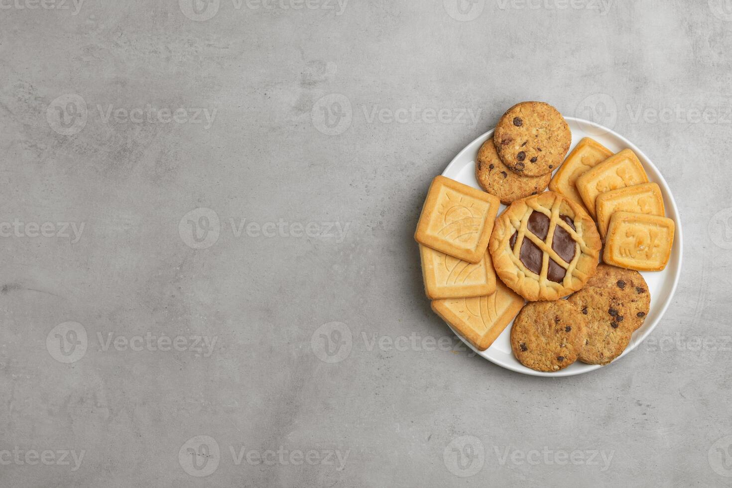 Set of cookies in a plate, gray concrete background. Top view, flat lay, copy space. photo
