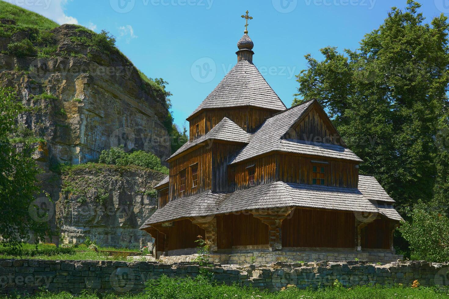 Christian wooden church on a warm sunny day among green trees photo