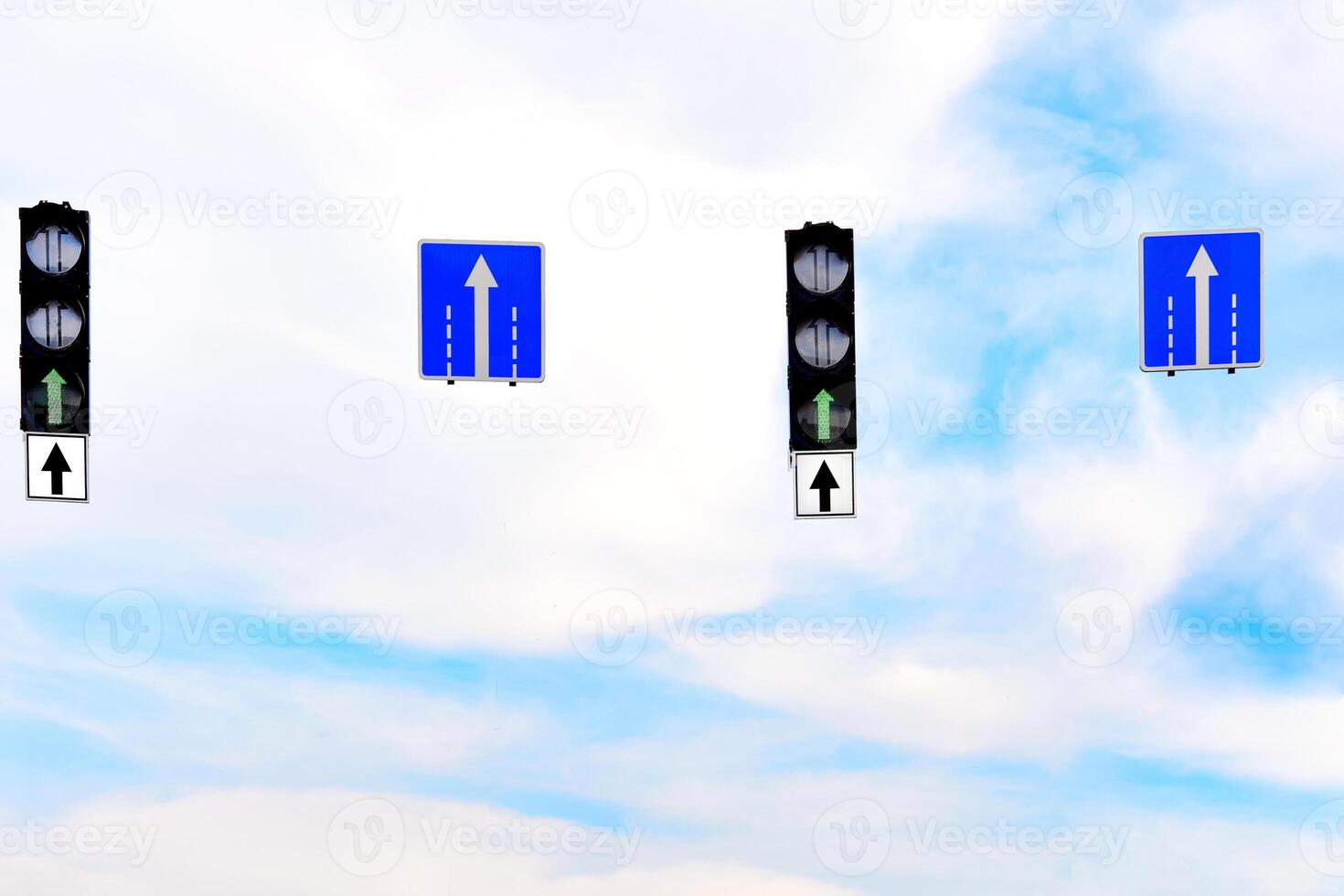 Forward. Green traffic light and a pointer directly against the blue sky photo