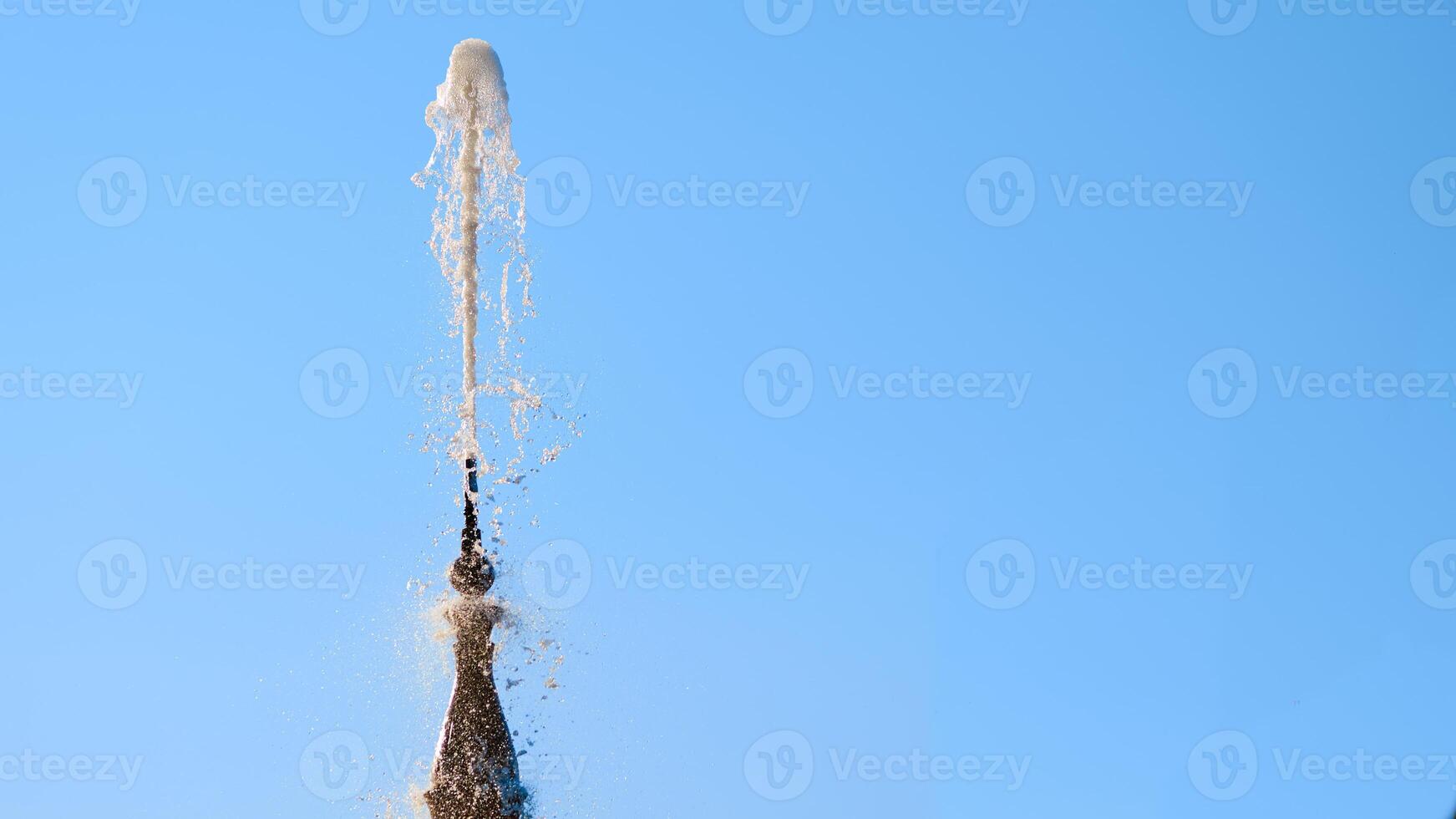 Fountain with shining clear liquid on a blue sky  background photo
