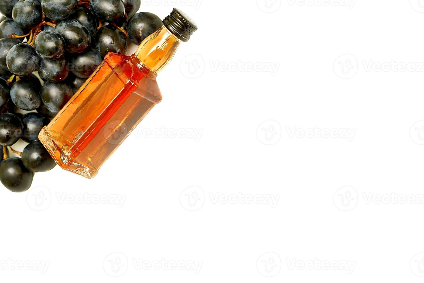 Black ripe grapes and good old brandy, cognac  on white photo