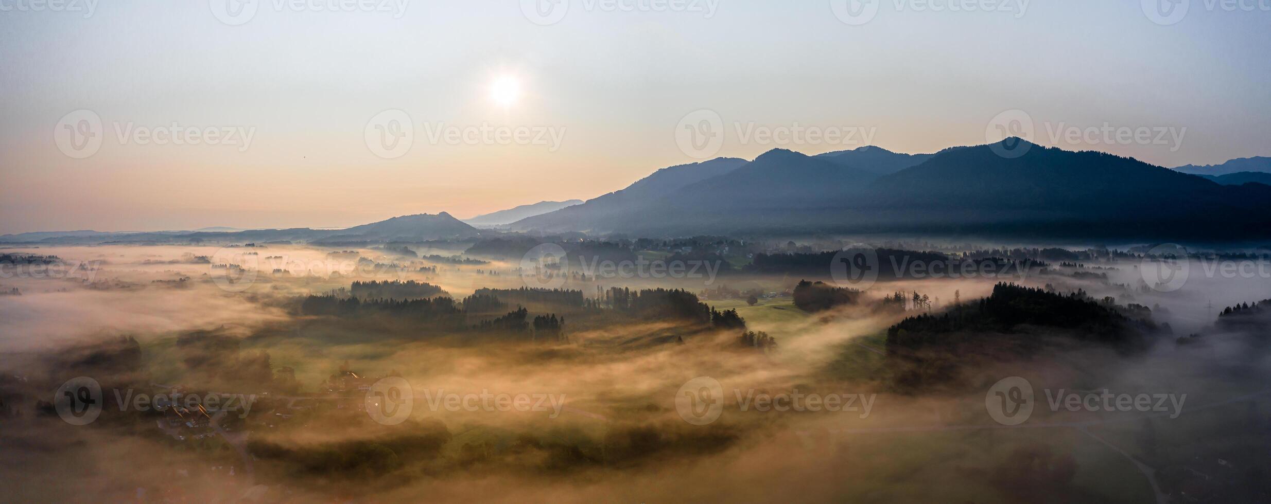 puesta de sol panorama con zumbido a el bávaro Alpes. niebla y niebla a el suelo foto