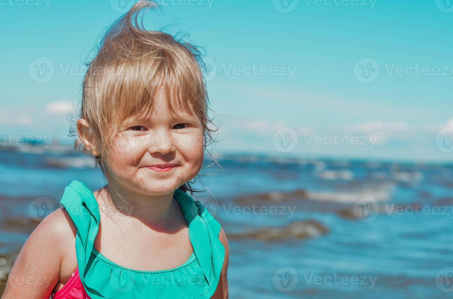 pequeño niña de europeo apariencia años de 4 4 retrato a el mar ,reír y mirando a el cámara, tropicales verano vocaciones,vacaciones.a niño disfruta el mar.copia espacio.cerrar arriba foto