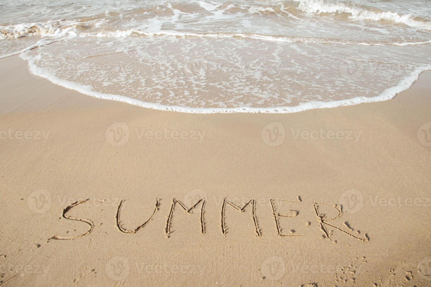 Summer 2023 lettering on the beach with wave and clear blue sea. Letters Summer 2023 on the sea shore, message handwritten in the golden sand on beautiful beach background. Summer Holidays 2023 concept. High quality photo