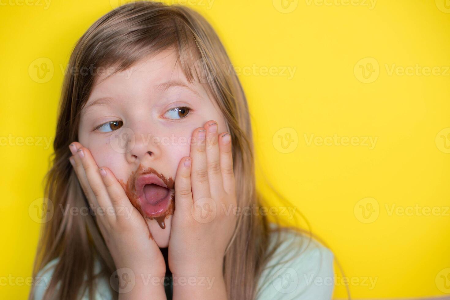 asustado pequeño niña comiendo chocolate sucio rostro. cerca arriba de niño con sucio cara en chocolate o nutella.copia espacio foto