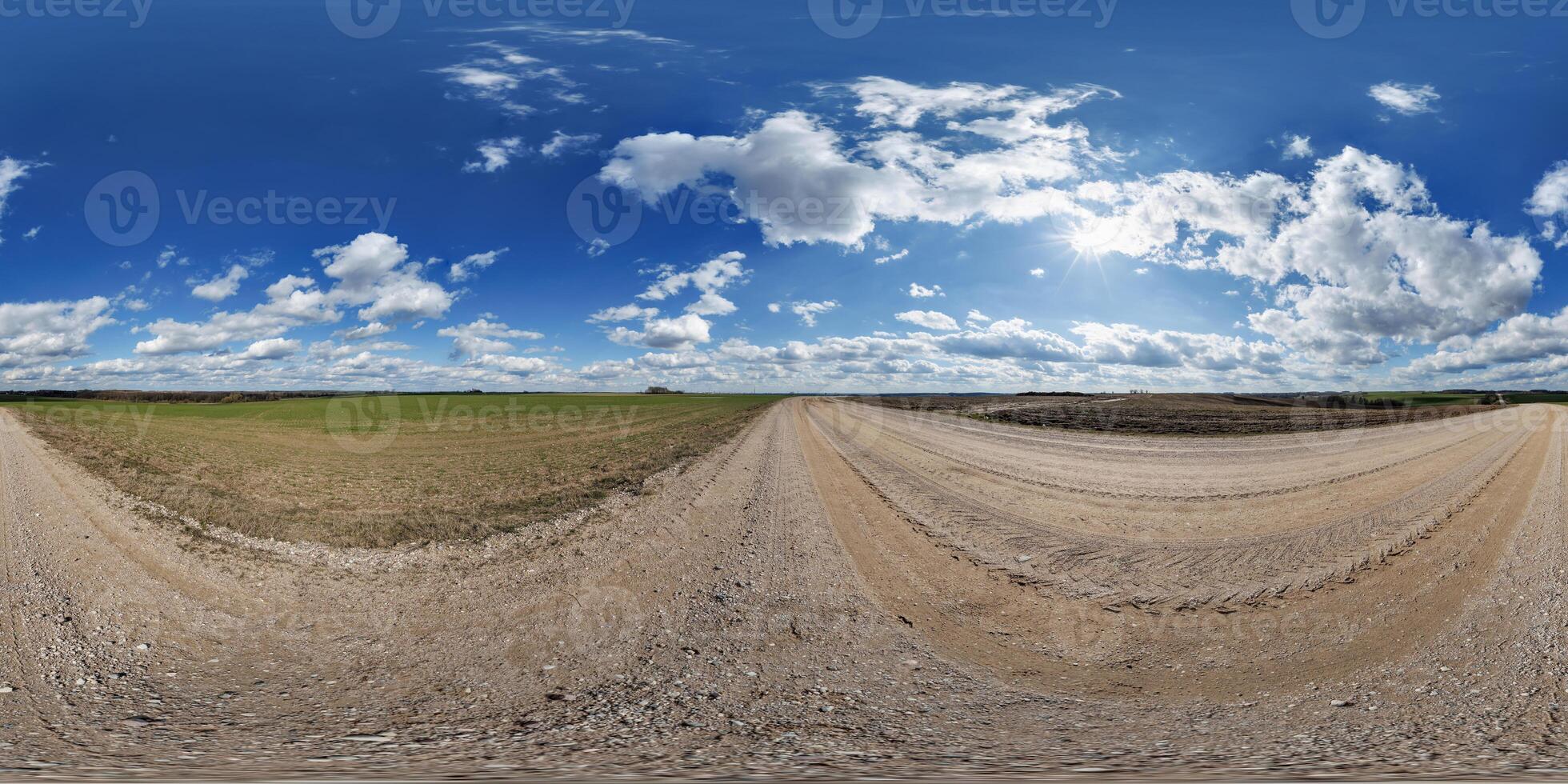 hdri 360 panorama on gravel road among fields in spring evening with awesome clouds in equirectangular full seamless spherical projection, for VR AR virtual reality content photo