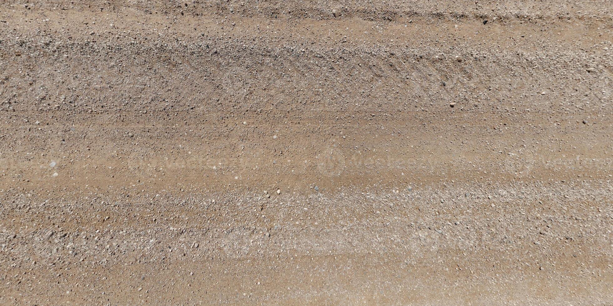 view from above on texture of gravel road with car tire tracks photo