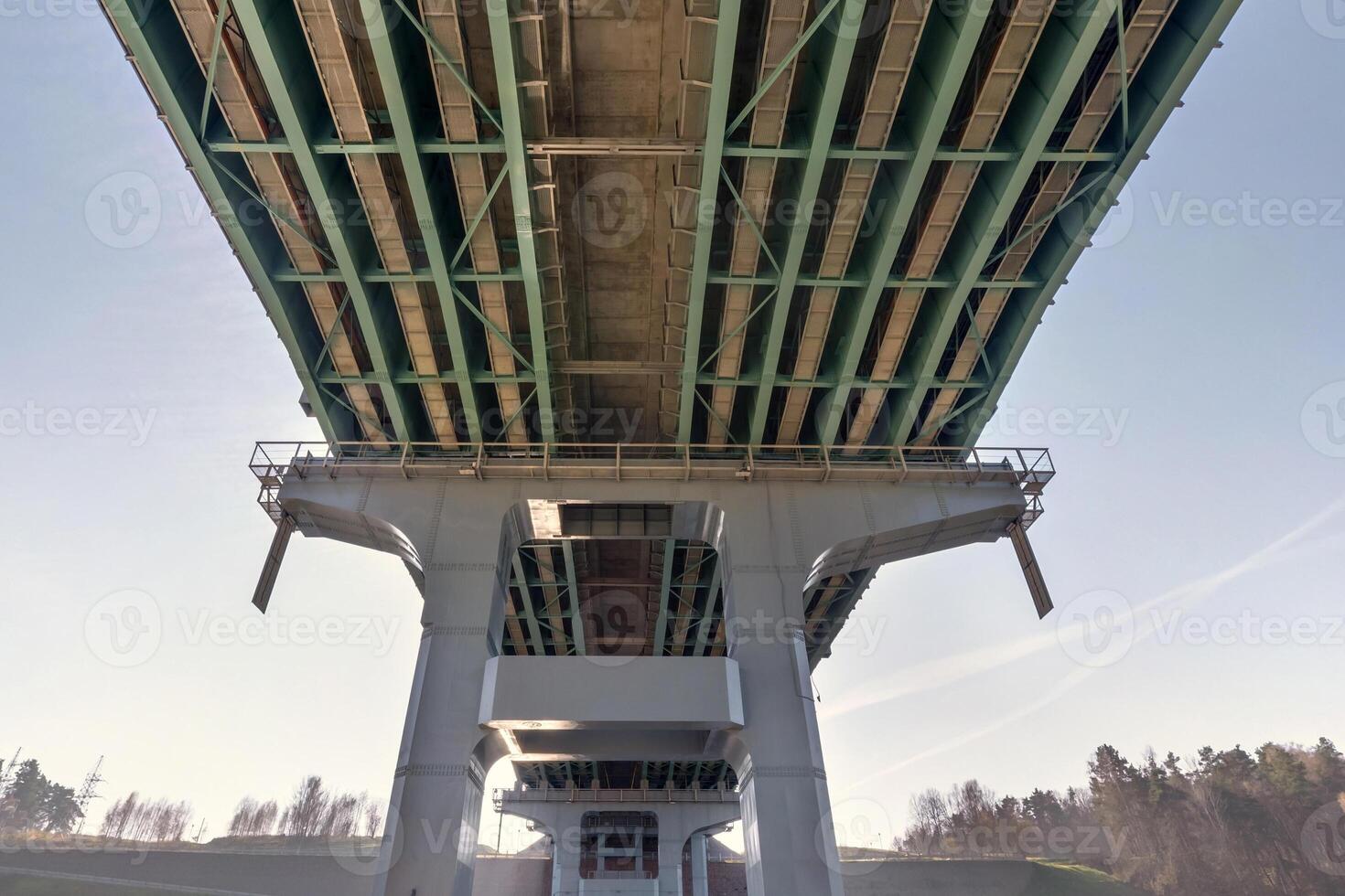 steel frame and concrete construction huge car bridge across the wide river. photo