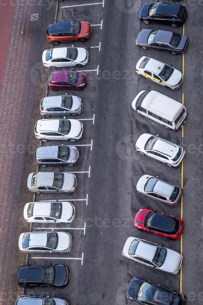 large parking lot for cars in front of a multi-storey residential building view from above photo