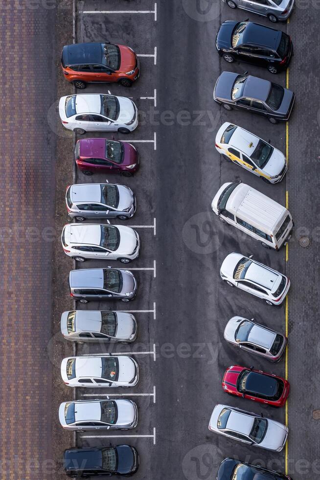 large parking lot for cars in front of a multi-storey residential building view from above photo