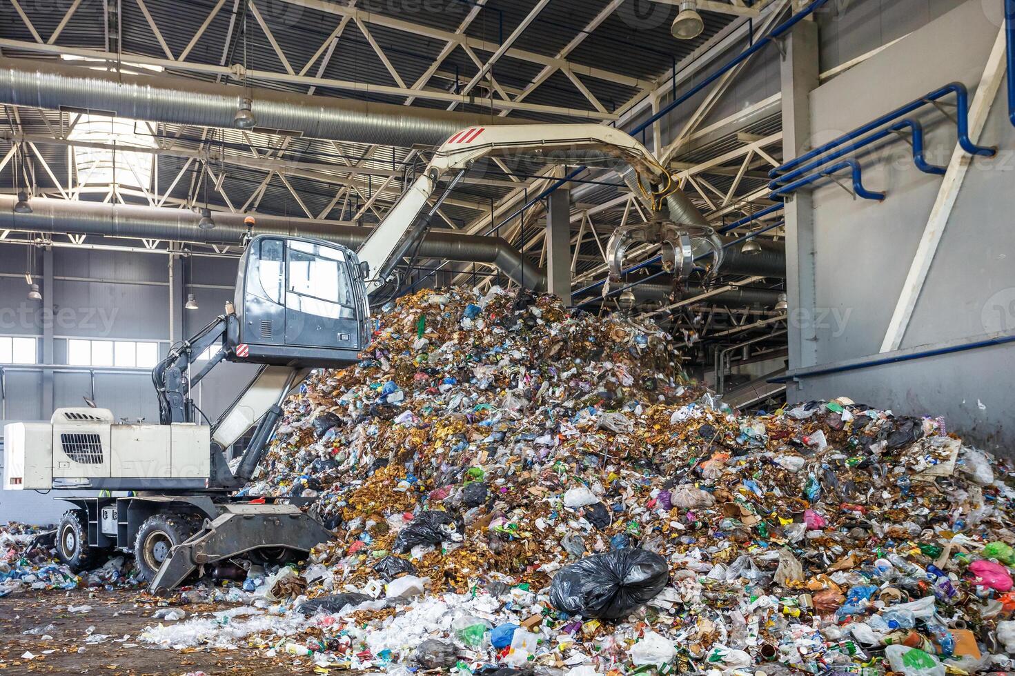 excavadora en la clasificación primaria de basura en la planta de procesamiento de residuos. recolección de basura por separado. reciclaje y almacenamiento de residuos para su posterior eliminación. foto