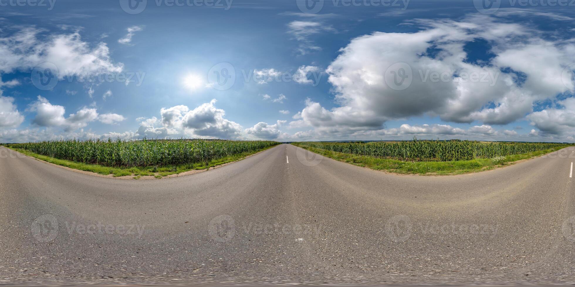 spherical 360 hdri panorama on old asphalt road among corn fields with clouds and sun on blue sky in equirectangular seamless projection, as skydome replacement in drone panoramas, game development photo
