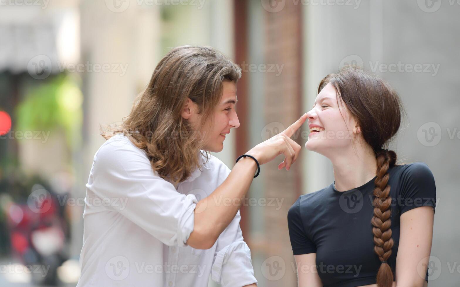 A couple is enjoying a summer vacation in the community streets, happily showing their love to each other. photo