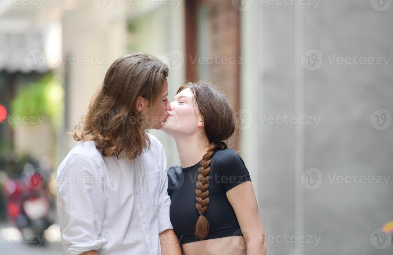 A couple is enjoying a summer vacation in the community streets, happily showing their love to each other. photo