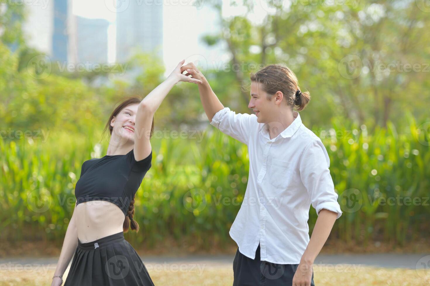 A couple is enjoying a summer vacation in the park, happily showing their love to each other. photo