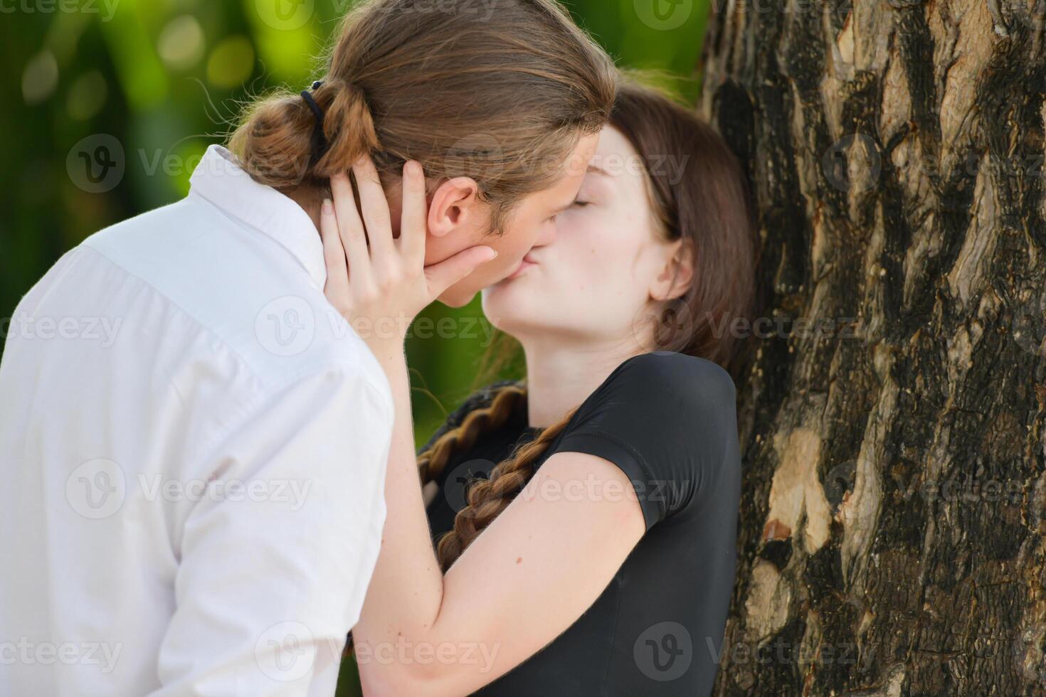 A couple is enjoying a summer vacation in the park, happily showing their love to each other. photo