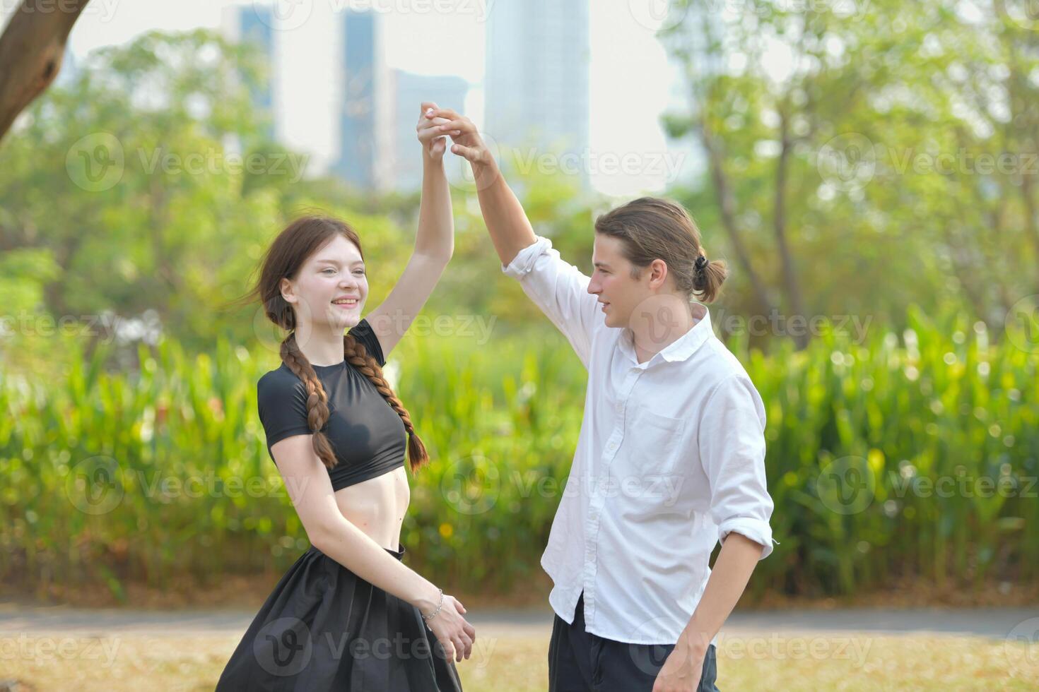 A couple is enjoying a summer vacation in the park, happily showing their love to each other. photo