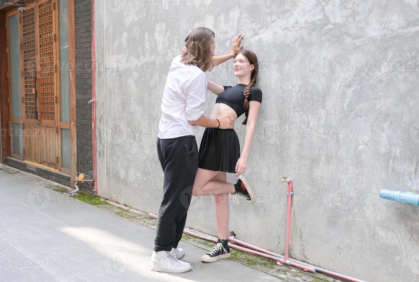 A couple is enjoying a summer vacation in the community streets, happily showing their love to each other. photo