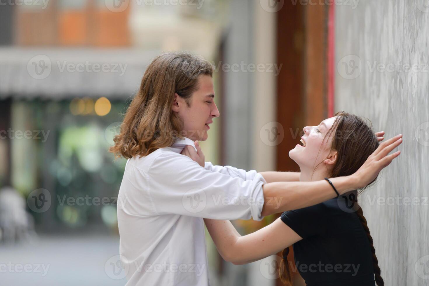 A couple is enjoying a summer vacation in the community streets, happily showing their love to each other. photo