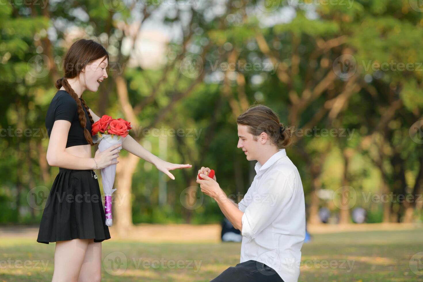 A couple is enjoying a summer vacation in the park, happily showing their love to each other. photo