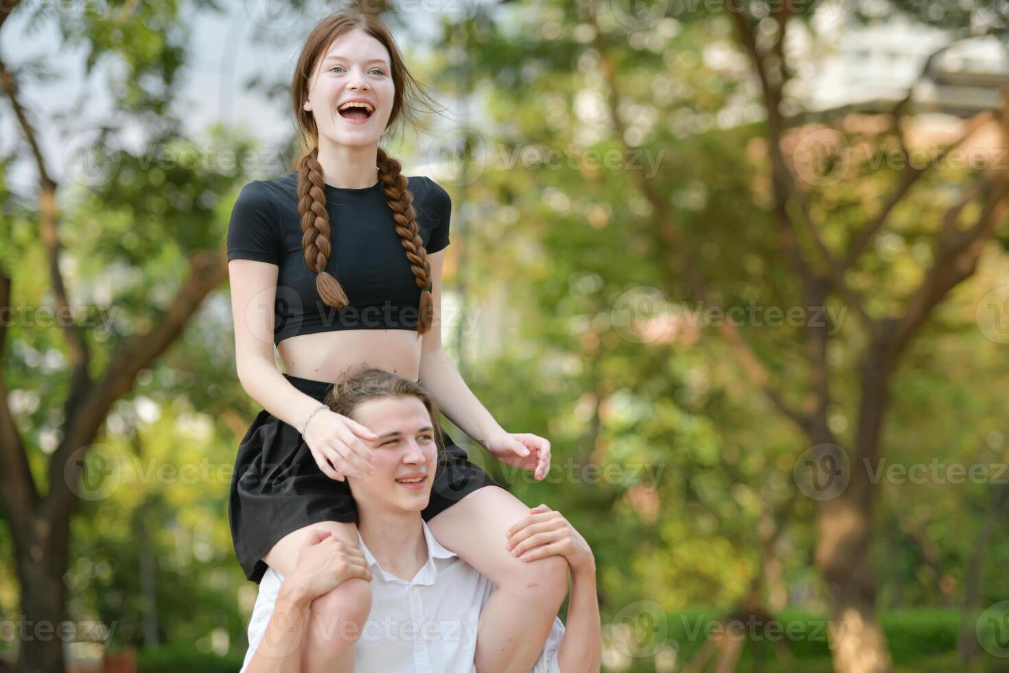 A couple is enjoying a summer vacation in the park, happily showing their love to each other. photo