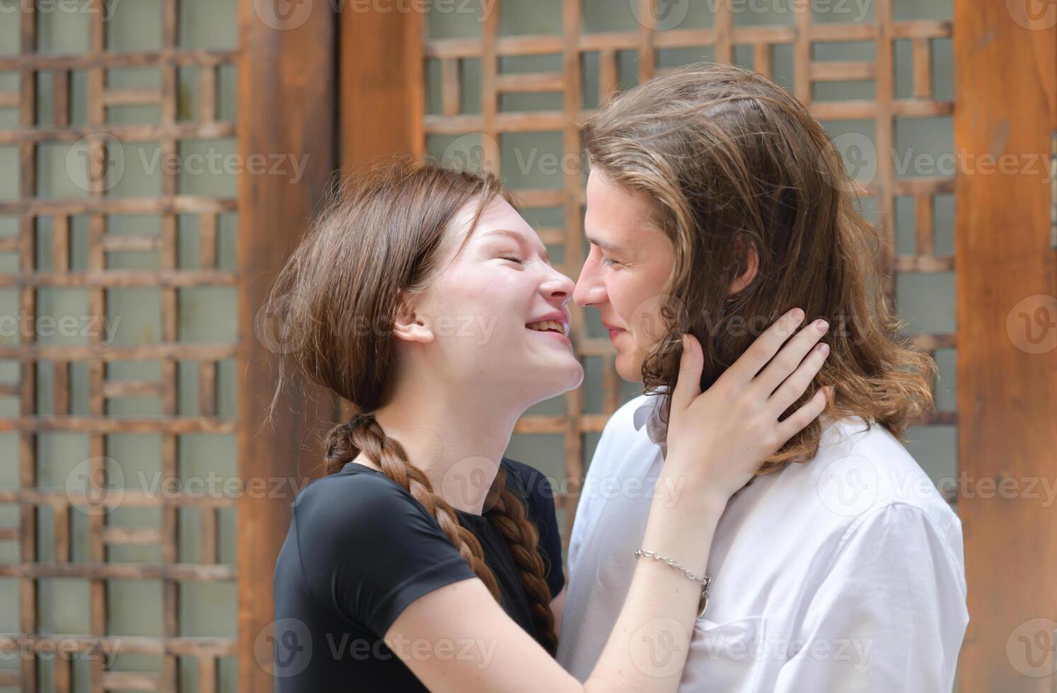 A couple is enjoying a summer vacation in the community streets, happily showing their love to each other. photo