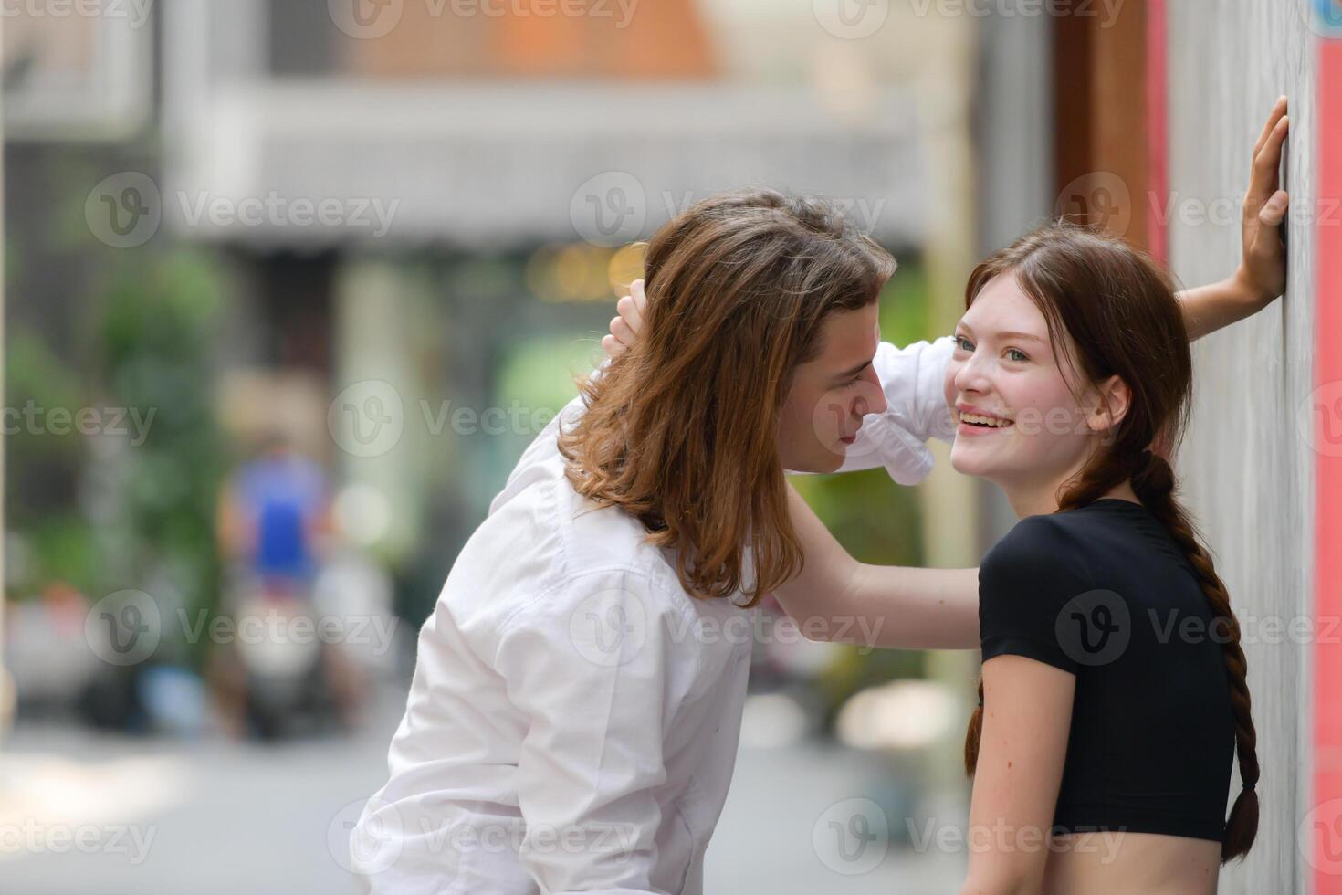 A couple is enjoying a summer vacation in the community streets, happily showing their love to each other. photo