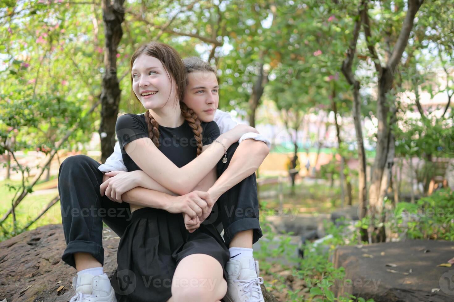 A couple is enjoying a summer vacation in the park, happily showing their love to each other. photo