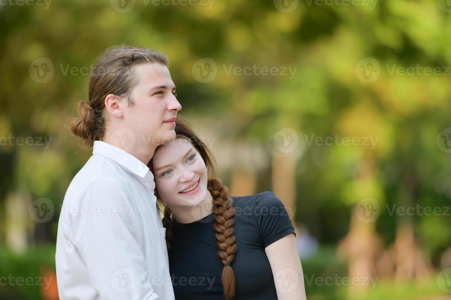 A couple is enjoying a summer vacation in the park, happily showing their love to each other. photo