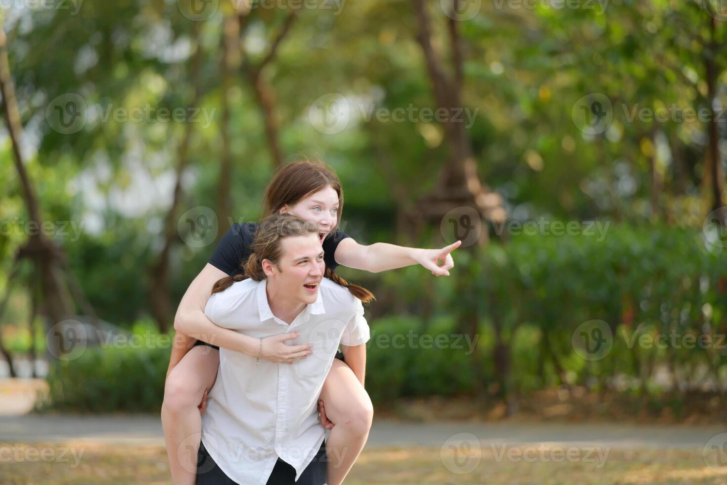 A couple is enjoying a summer vacation in the park, happily showing their love to each other. photo