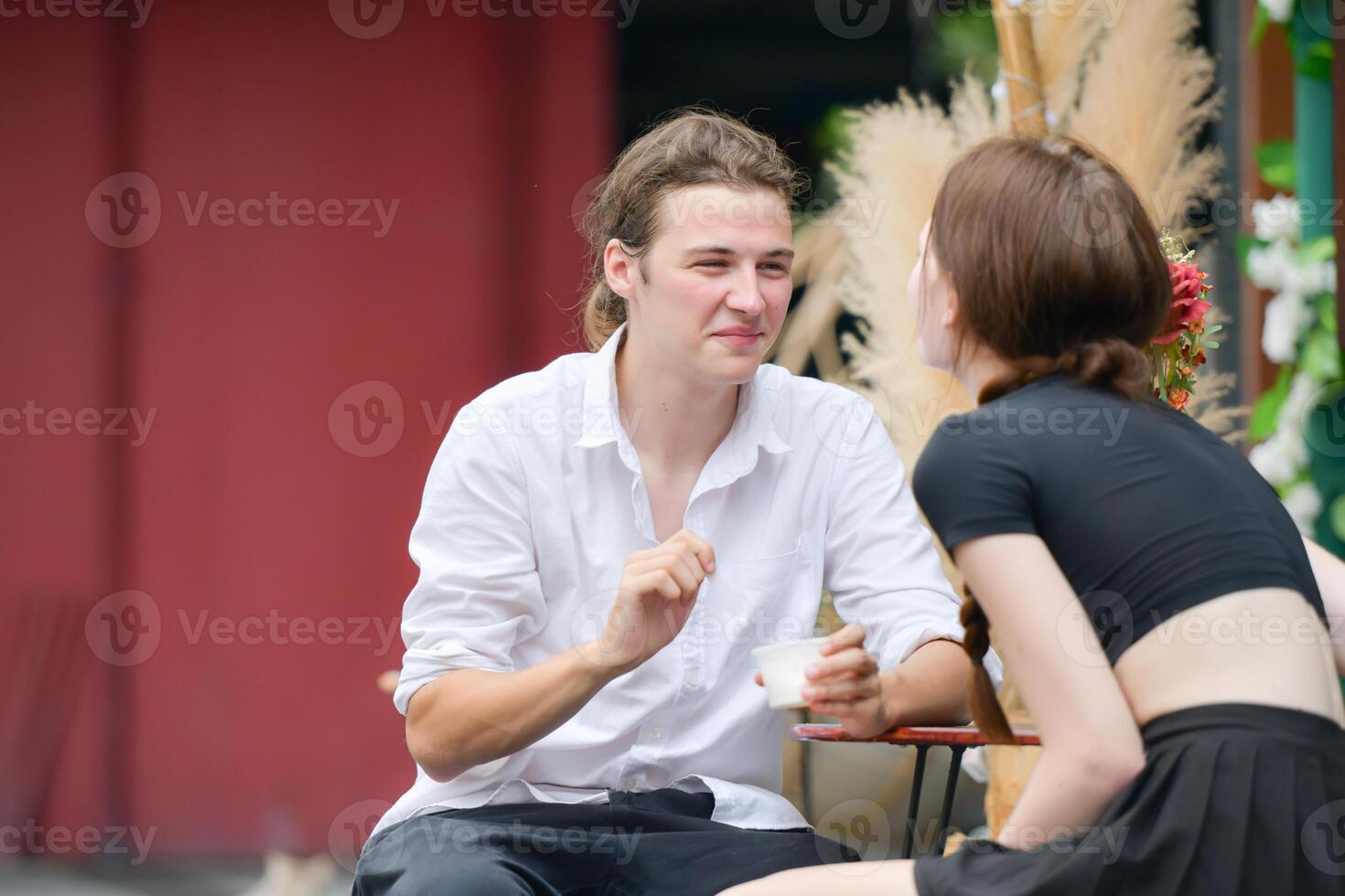 A couple is enjoying a summer vacation in the community area, happily showing their love to each other. photo