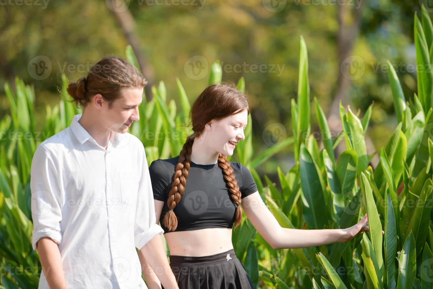 A couple is enjoying a summer vacation in the park, happily showing their love to each other. photo