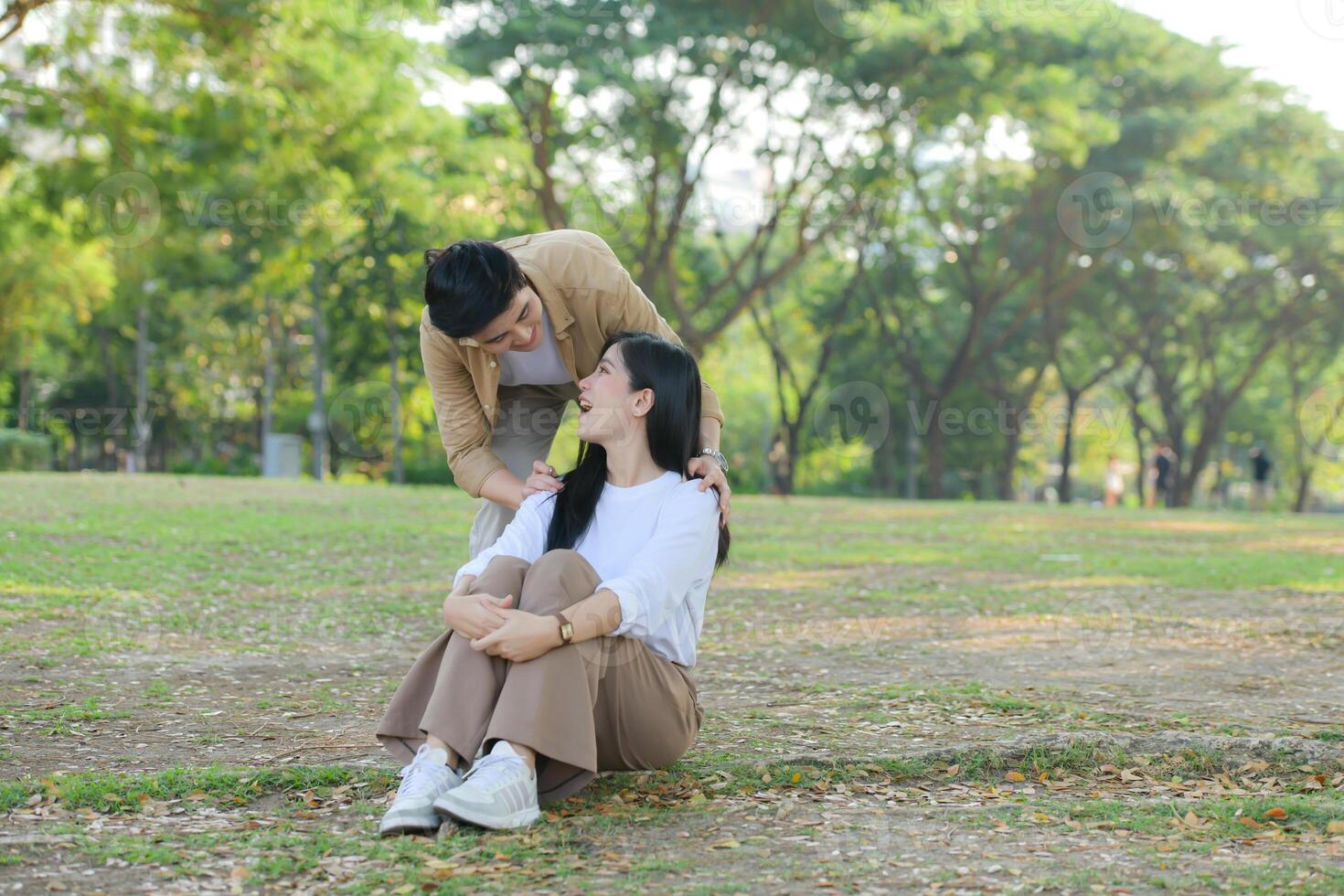 LGBT couple is enjoying a summer vacation in the park, happily showing their love to each other. photo