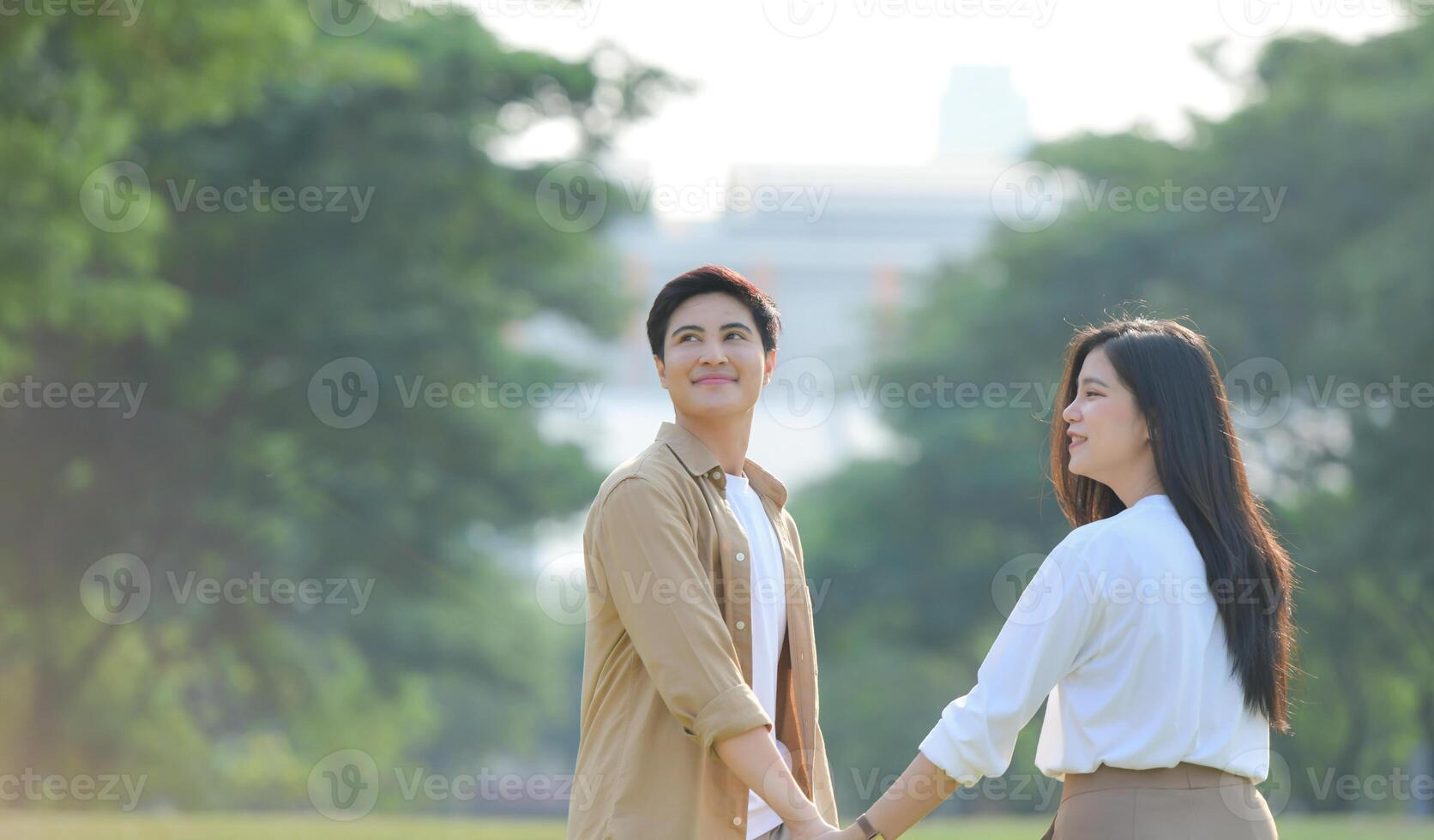 LGBT couple is enjoying a summer vacation in the park, happily showing their love to each other. photo