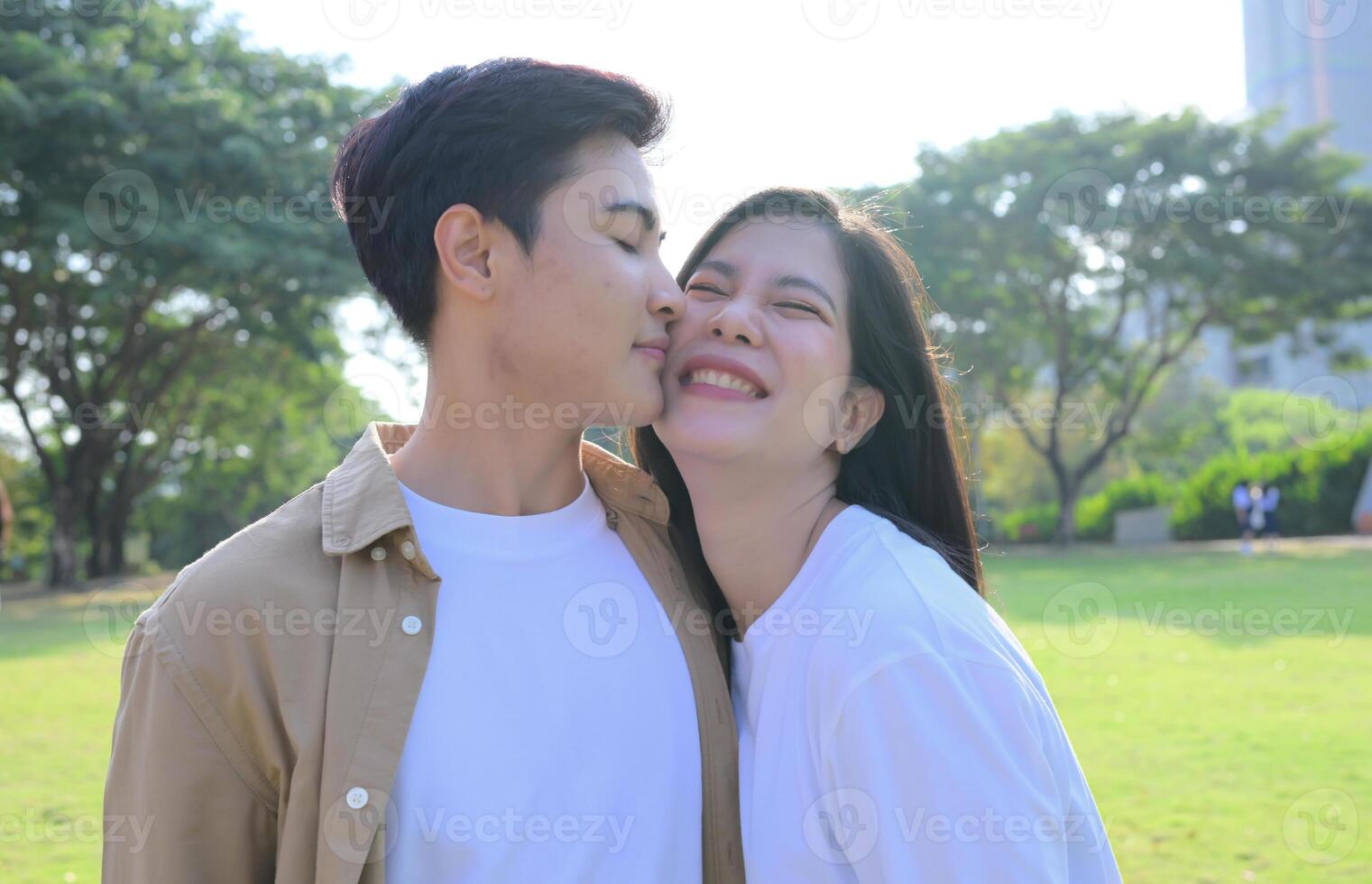 LGBT couple is enjoying a summer vacation in the park, happily showing their love to each other. photo