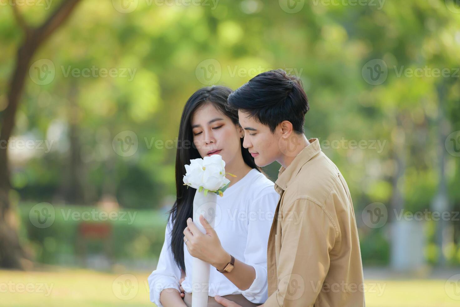 LGBT couple is enjoying a summer vacation in the park, happily showing their love to each other. photo