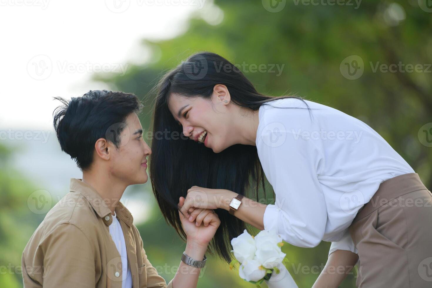 LGBT couple is enjoying a summer vacation in the park, happily showing their love to each other. photo