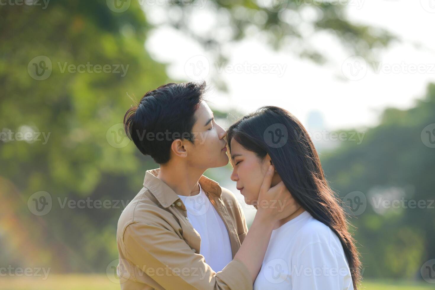 LGBT couple is enjoying a summer vacation in the park, happily showing their love to each other. photo