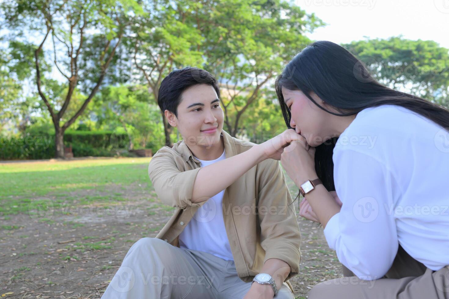 LGBT couple is enjoying a summer vacation in the park, happily showing their love to each other. photo