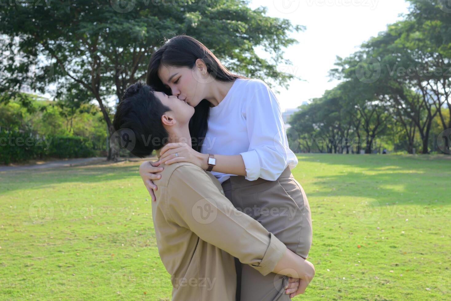 LGBT couple is enjoying a summer vacation in the park, happily showing their love to each other. photo