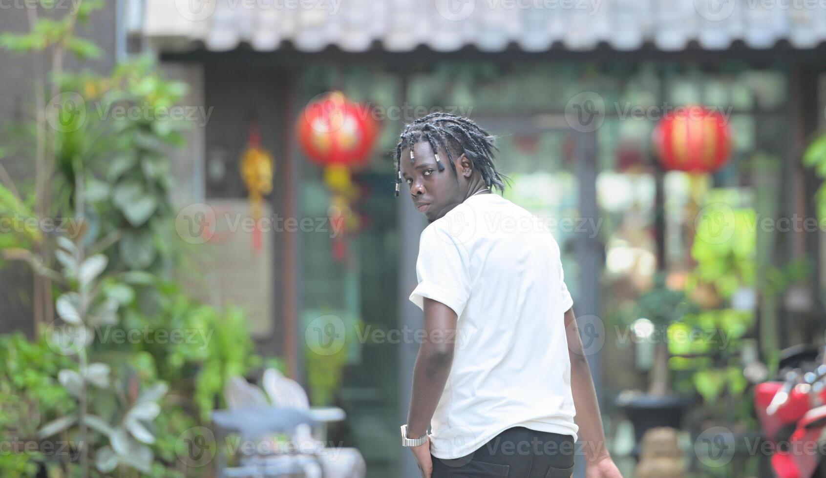 A young man with his hairstyle and the atmosphere of living in the community. photo