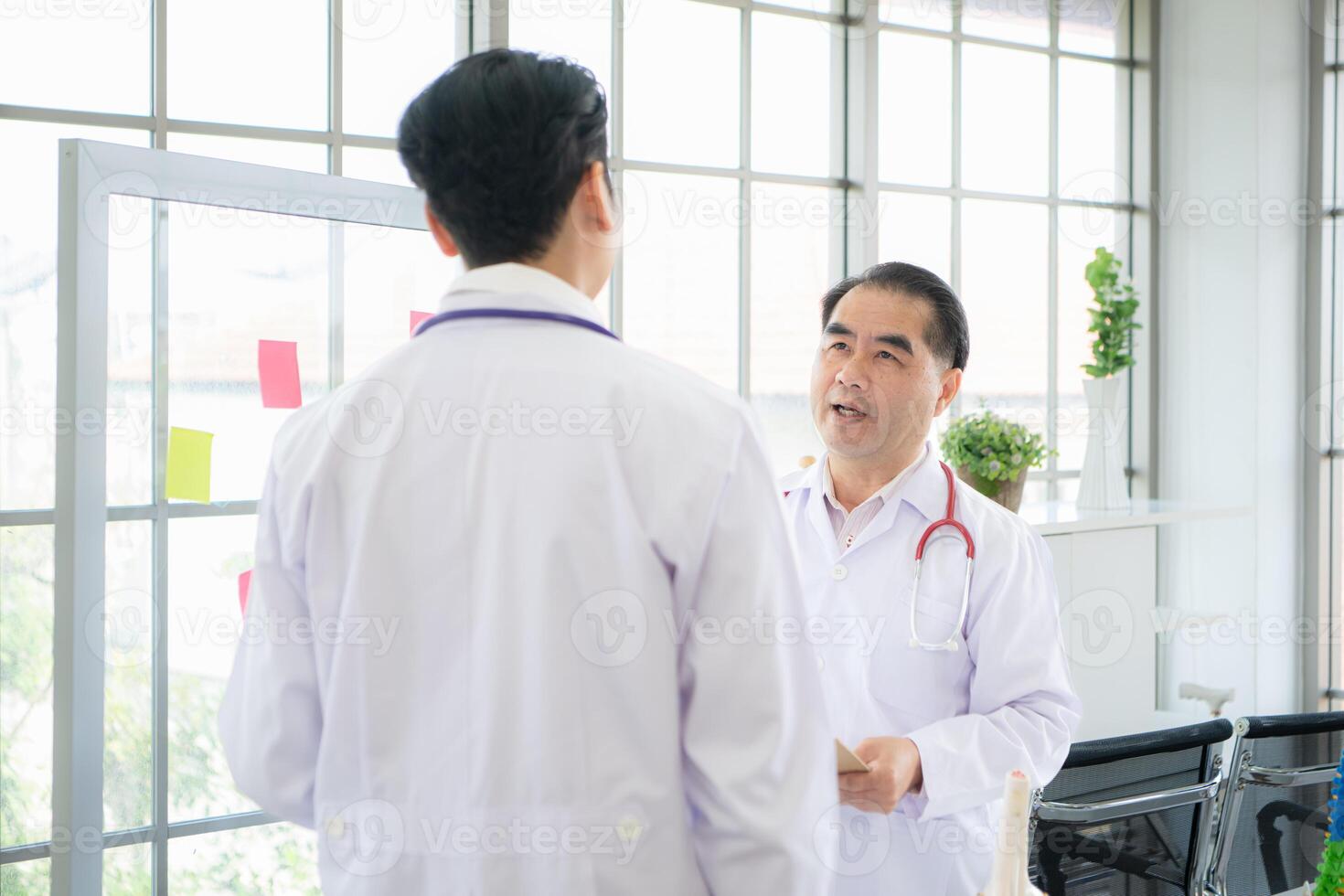 un médico profesor y un médico estudiante discutir un caso estudiar involucrando enfermedad terapia para un hospital paciente. foto