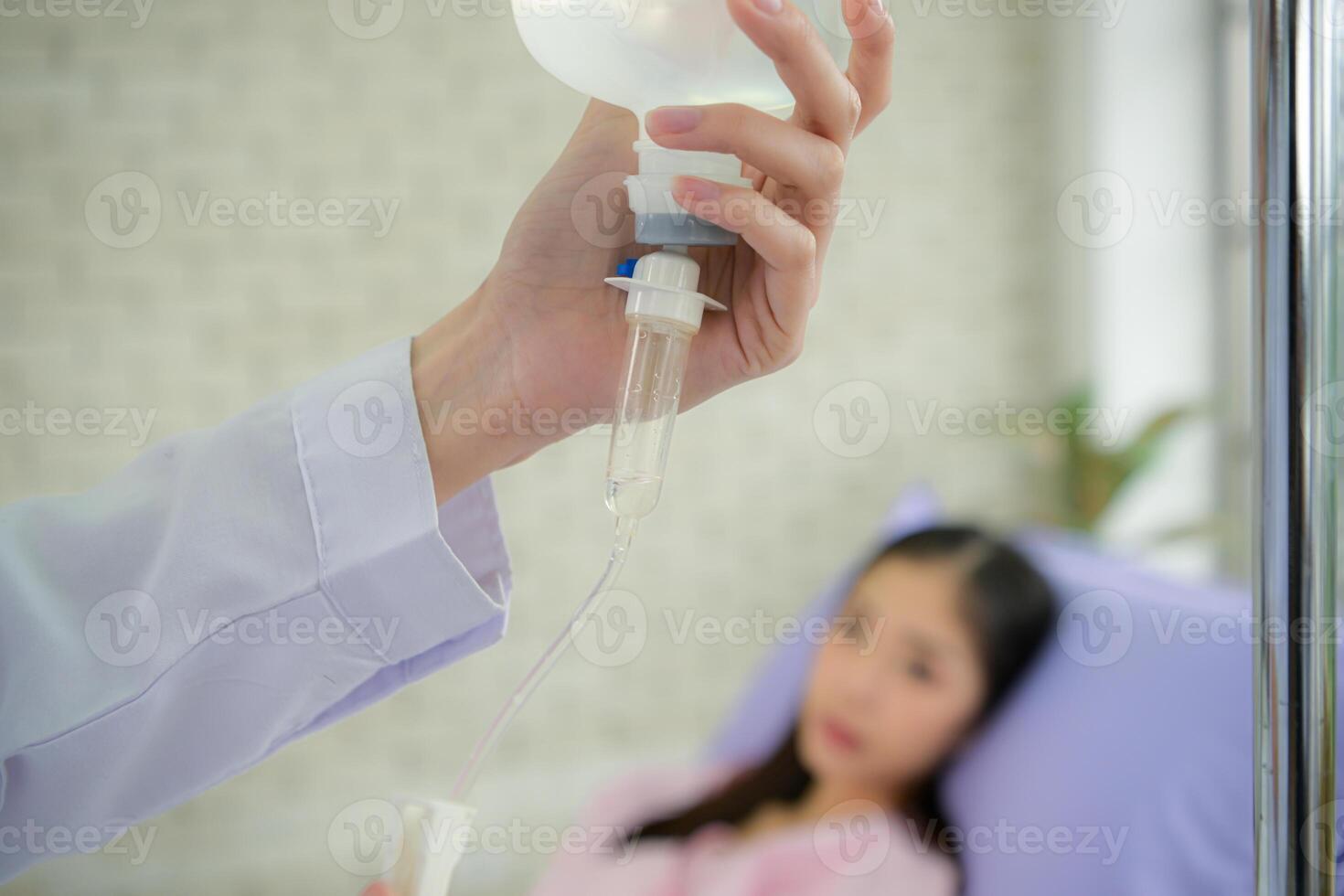 Female doctor with IV equipment will give IV fluids and examine patients lying in hospital beds photo